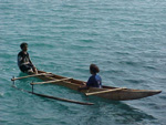 Paddling a canoe out to sea, Papua New Guinea photo